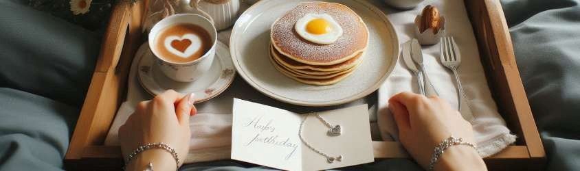 A beautifully arranged breakfast tray with pancakes, fresh fruit, a cup of coffee, and a small vase of flowers, prepared for Mother’s Day breakfast in bed.